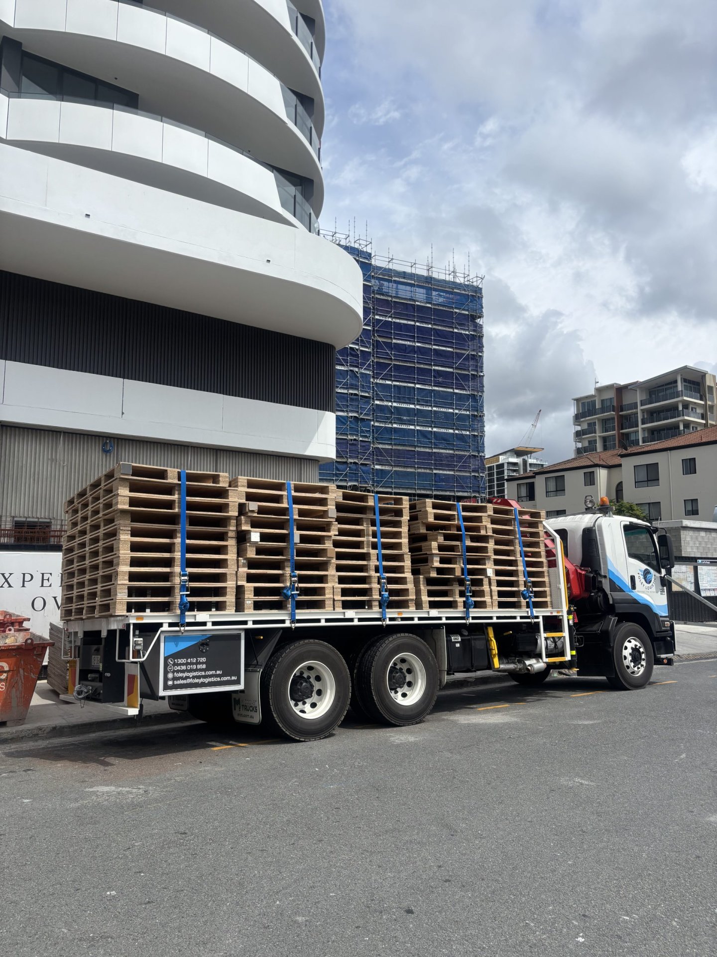 Foley Logistics crane truck carrying pallets at Chevron One Residences