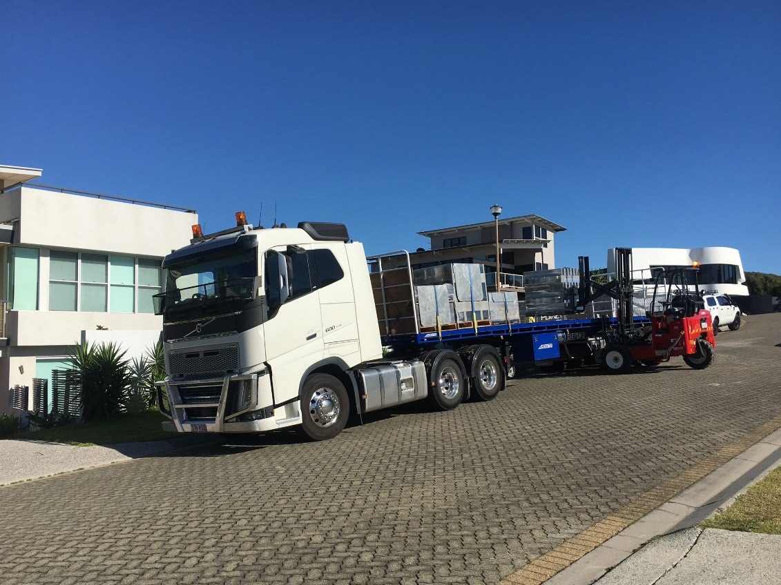 Foley Logistics prime mover, flatbed trailer and operational Moffett equipment