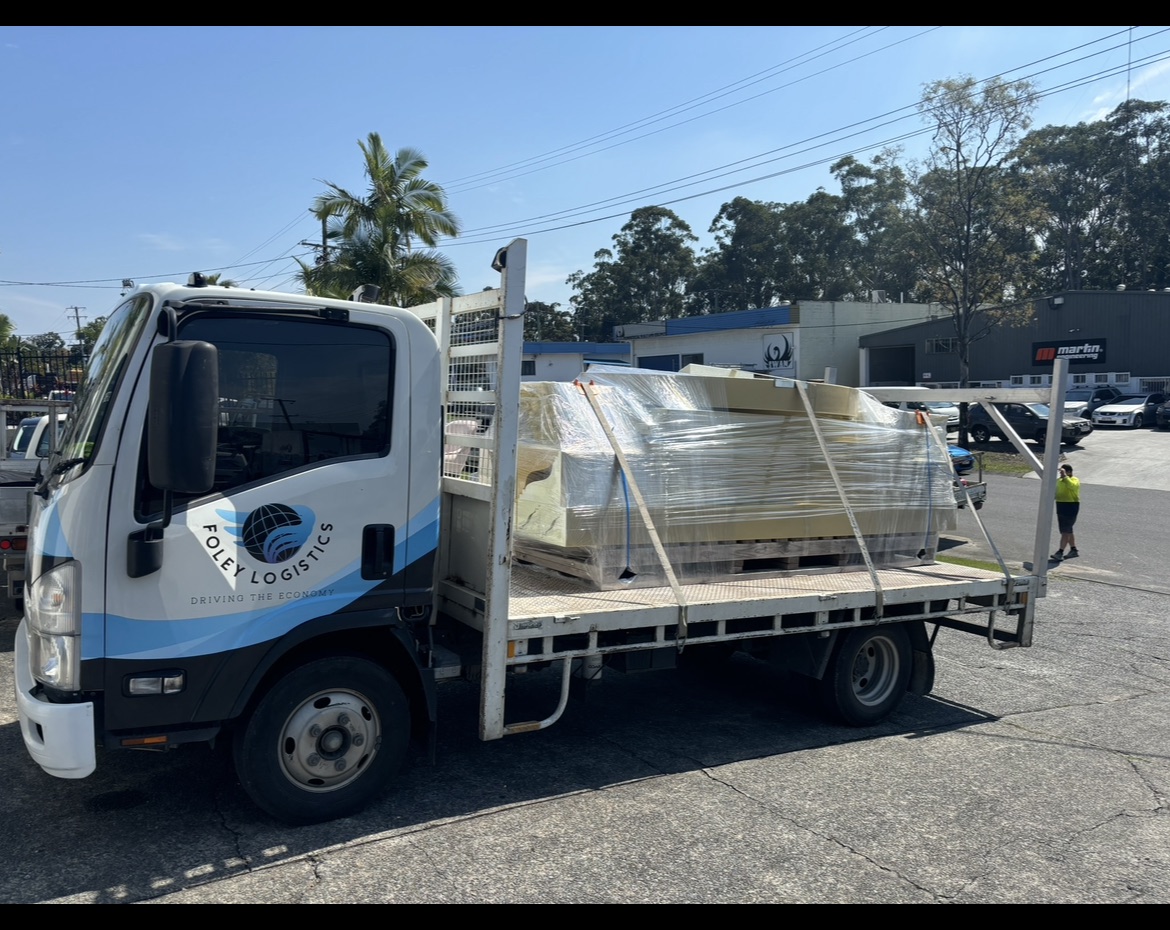 Foley Logistics flatbed taxi truck carrying palletised freight