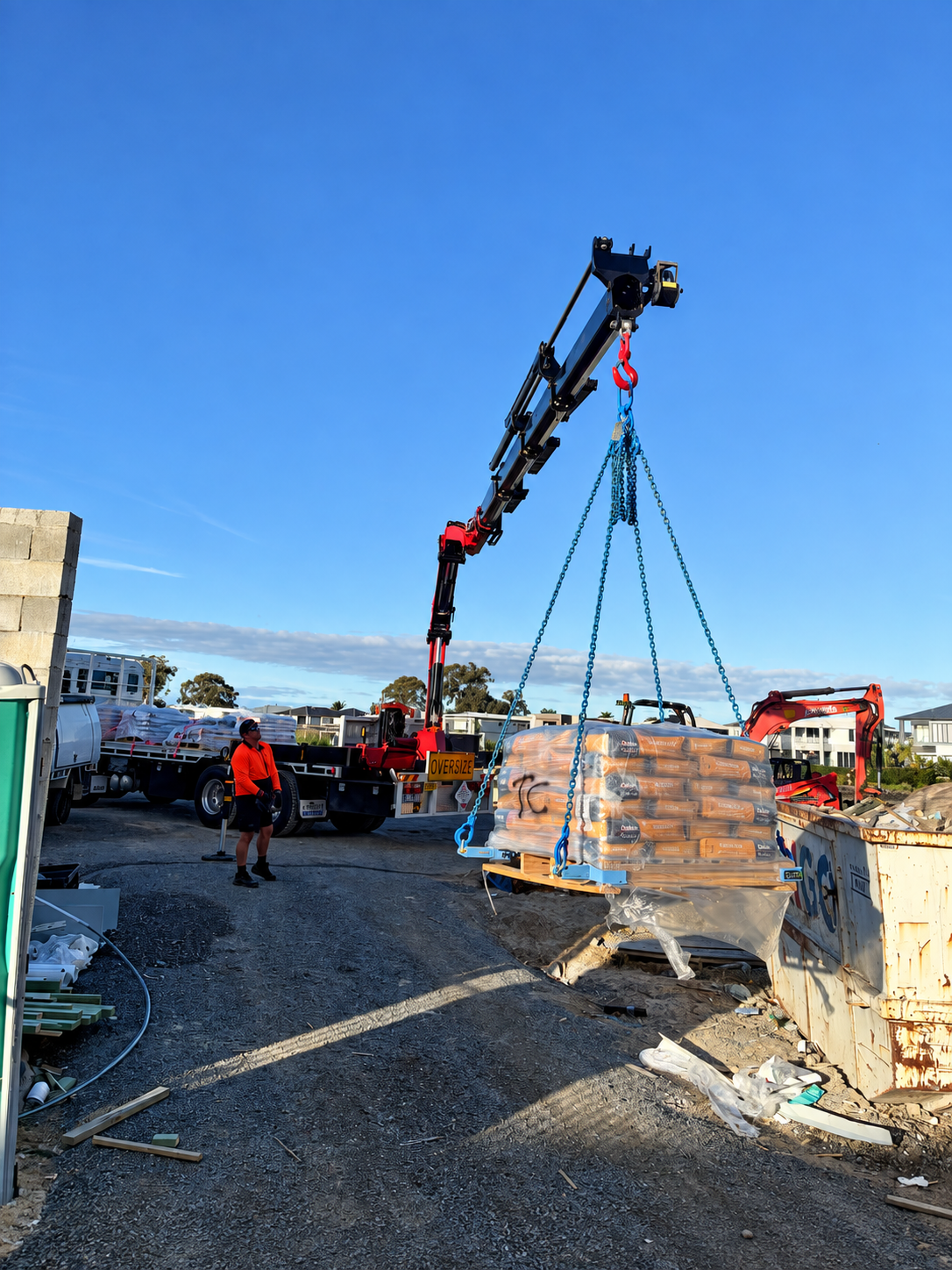 Foley Logistics crane truck and courier vehicle loaded with palletised render materials
